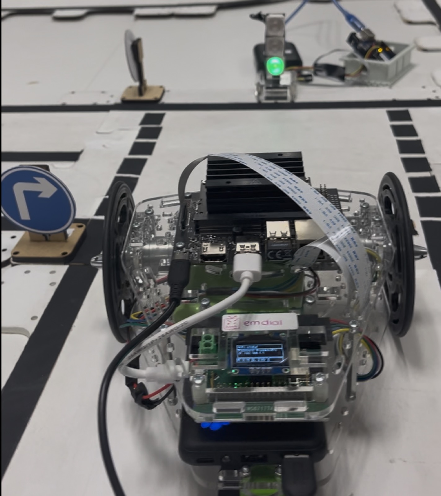 Differential-drive Puzzlebot following a marked track beside traffic signs.